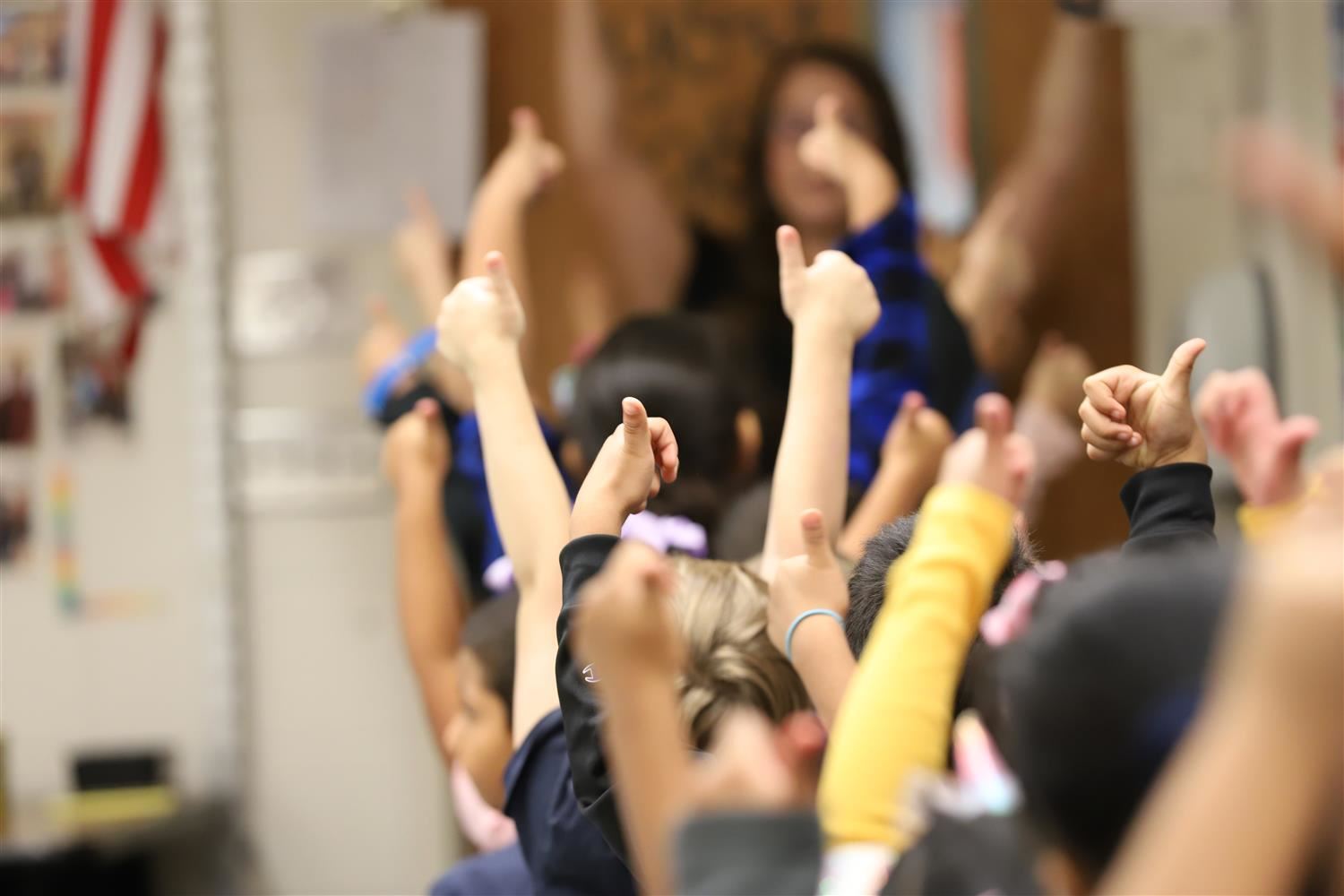 Elementary students in Knickrehm classroom giving a thumbs up to their teacher.